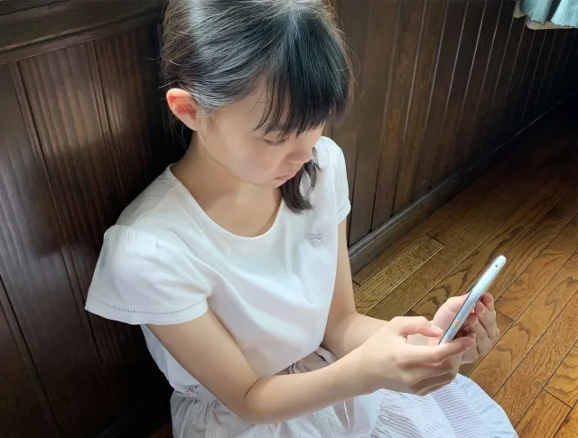スマホを見る子どもの画像